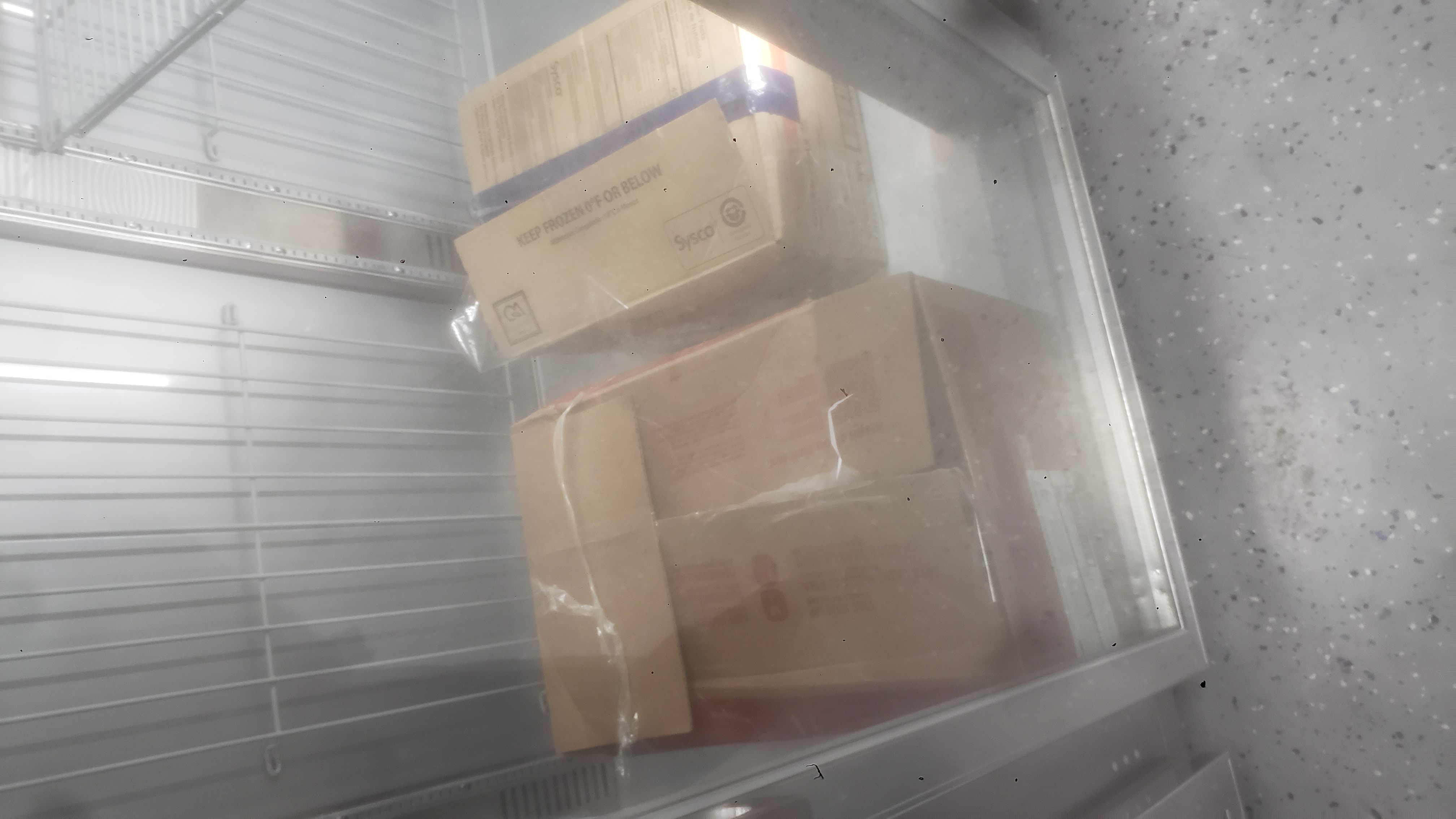 Cardboard boxes on the bottom of a freezer.